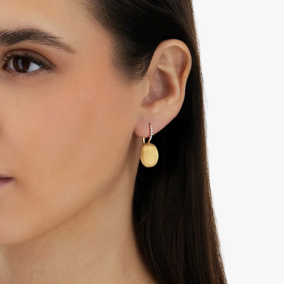 Nanis 18k gold drop earrings with diamond detail on model
