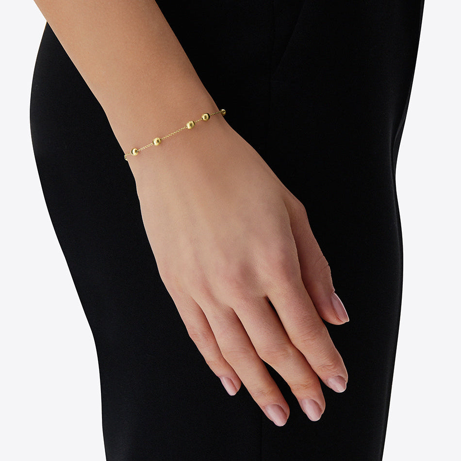 The Nanis Soffio Bracelet captures the lightness and contemporary Italian elegance at the heart of the Nanis aesthetic. Part of the Soffio collection, its delicate composition of polished gold boules creates a fluid rhythm around the wrist, lending the design an understated yet distinctive presence.