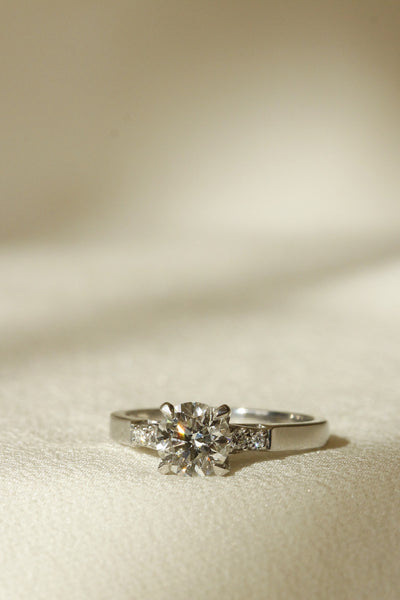 Vertical image of engagement ring with round diamond and diamonds set on sides Galvani setting 