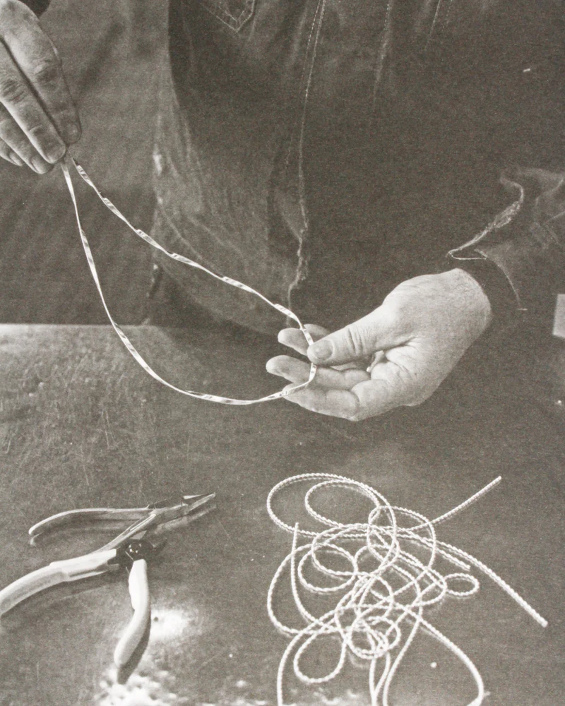 Jeweller_holding_a_gold_neclace_in_a_workshop