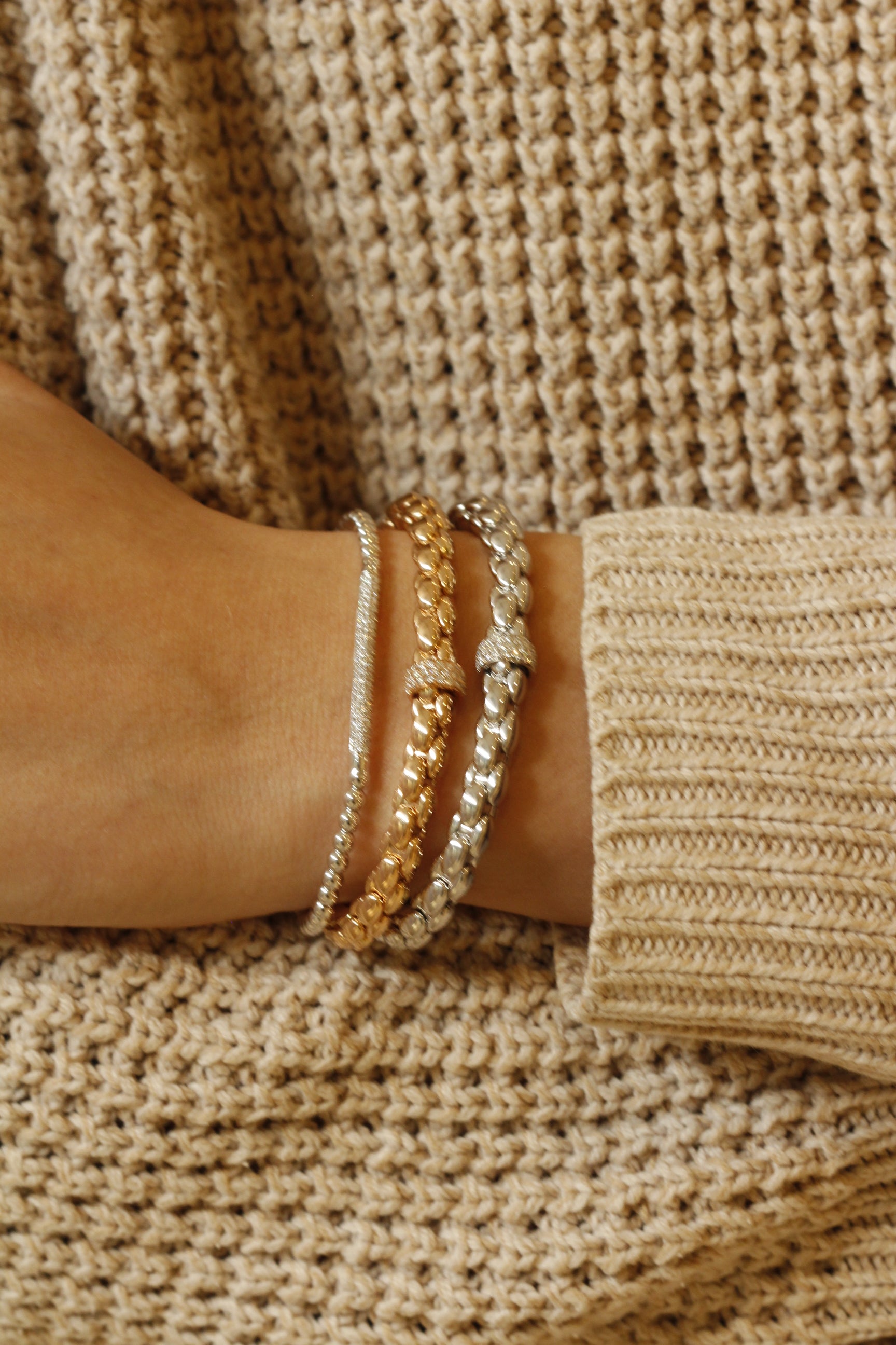 Image of bracelets and rings by designer brand Hulchi Belluni worn on a model