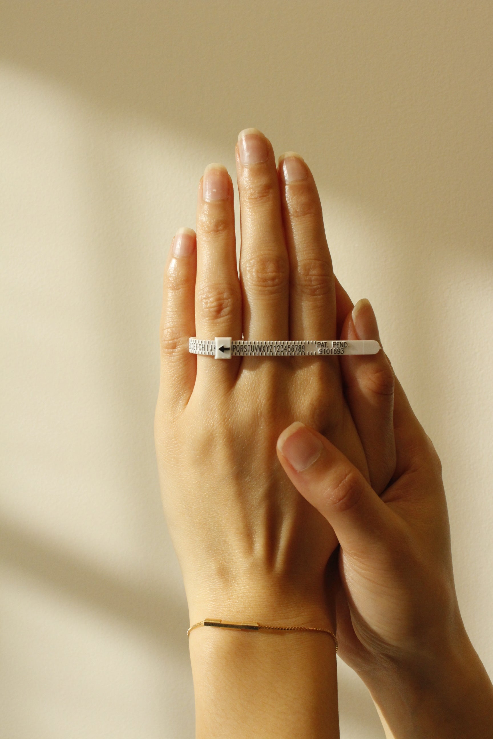 Finger Sizer for engagement rings wedding rings and rings on a hand with a gold bracelet
