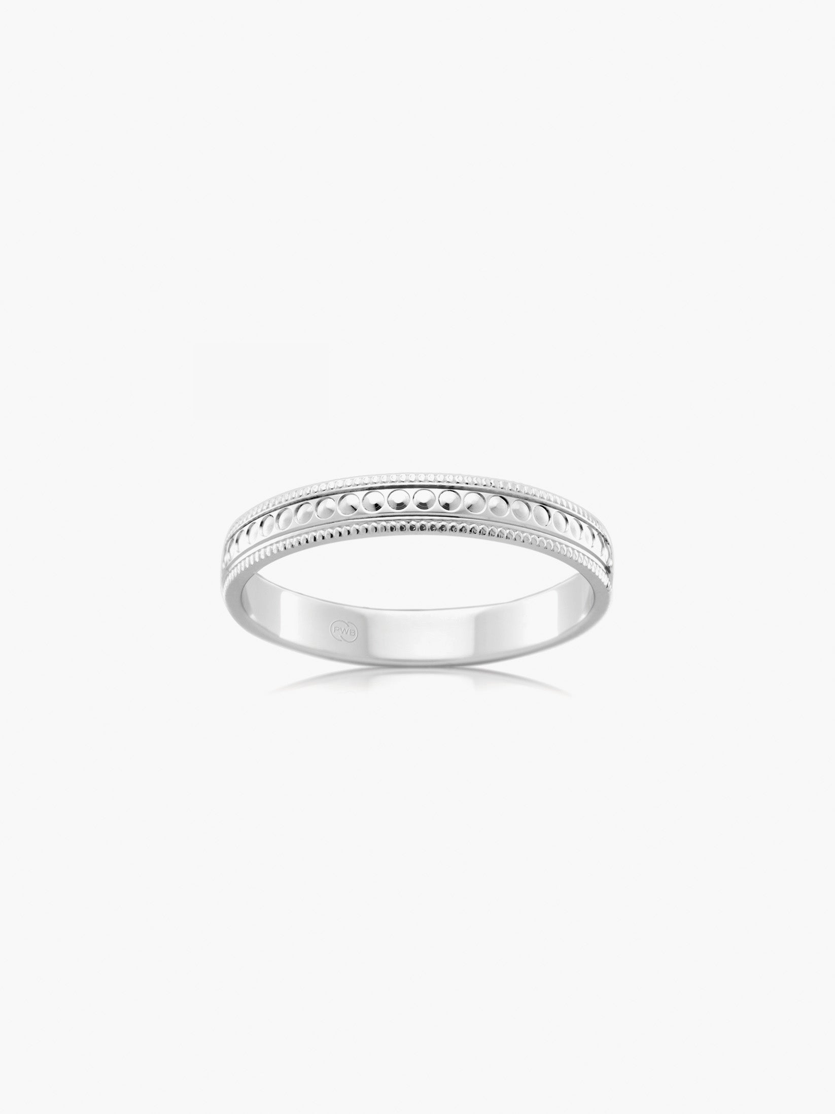 A contemporary wedding ring in white gold, defined by fine milgrain edges and a textured studded centre.