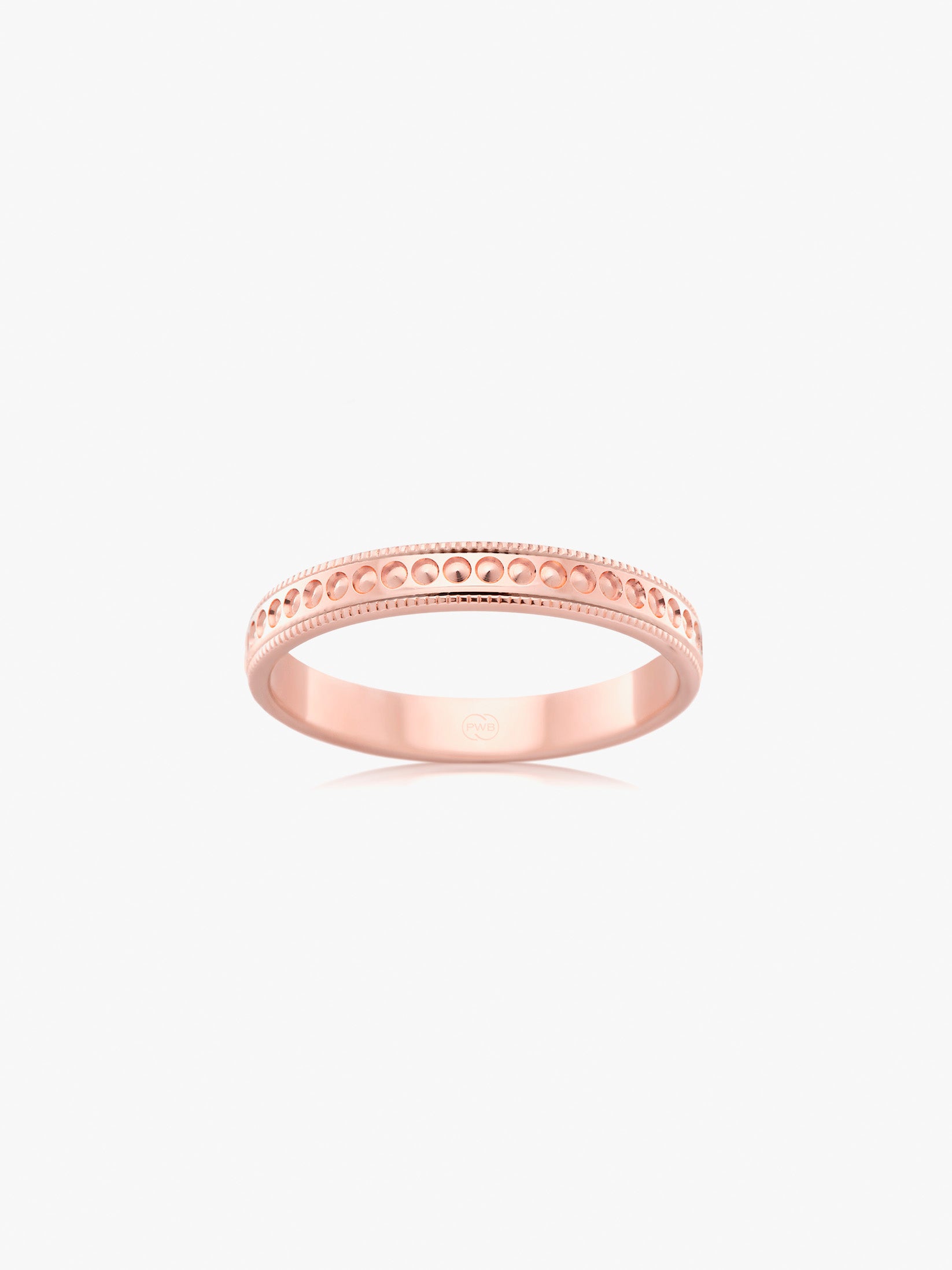 A warm-toned wedding ring in rose gold, accented by delicate milgrain edges and a softly textured centre.