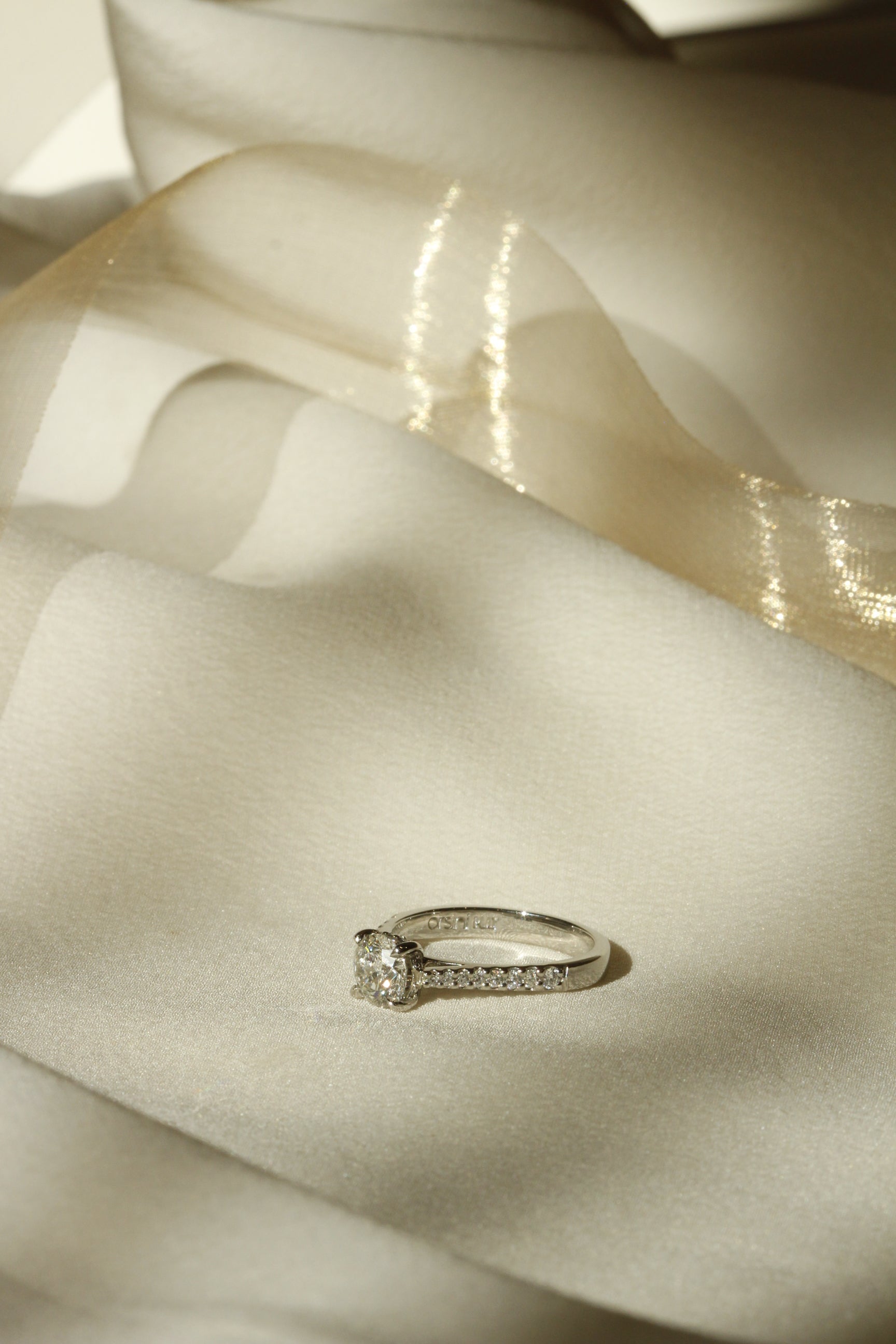 Bernini engagement ring on white fabric with gold ribbon in background Orsini Fine Jewellery