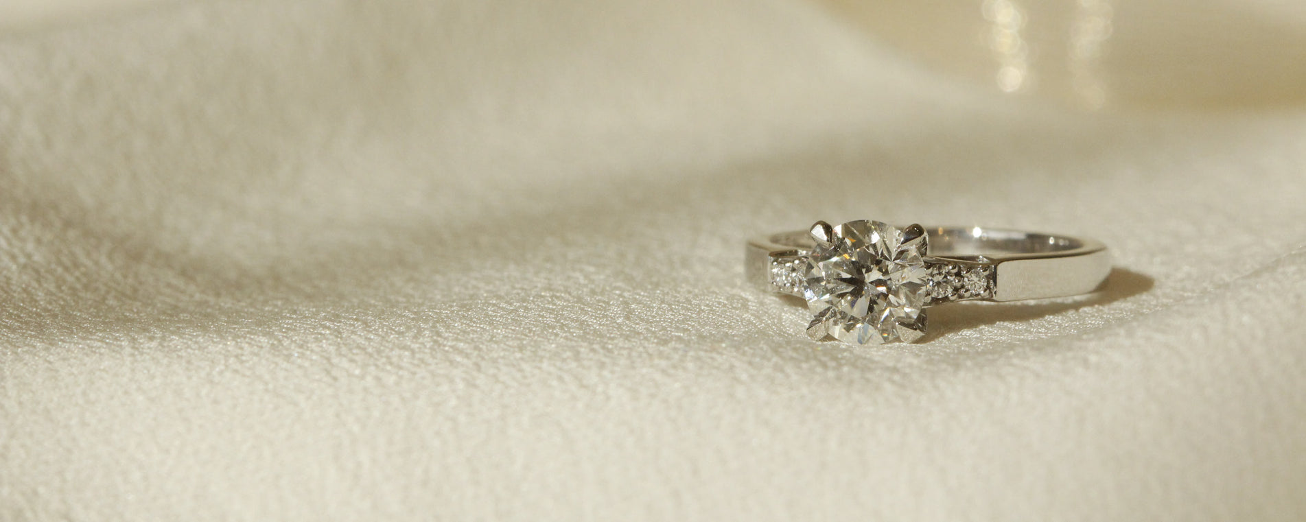 Engagement ring with solitaire centre stone on white gold band with diamonds on sides horizontal image Galvani Orsini Fine Jewellery setting