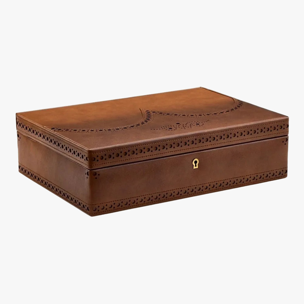 Store ten timepieces in the refined style of English brogue shoemaking. Lock-and-key closure, suspended cushions and integrated smartwatch USB port.