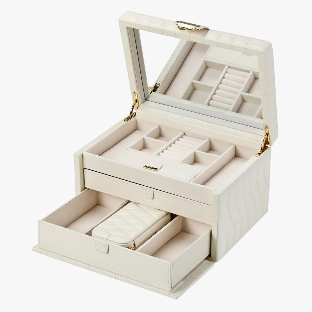 Crafted in ivory leather, the thoughtfully designed interior includes 15 storage compartments, 7 ring rolls, a removable travel case with additional ring rolls and compartments, and a travel pouch for smaller valuables.