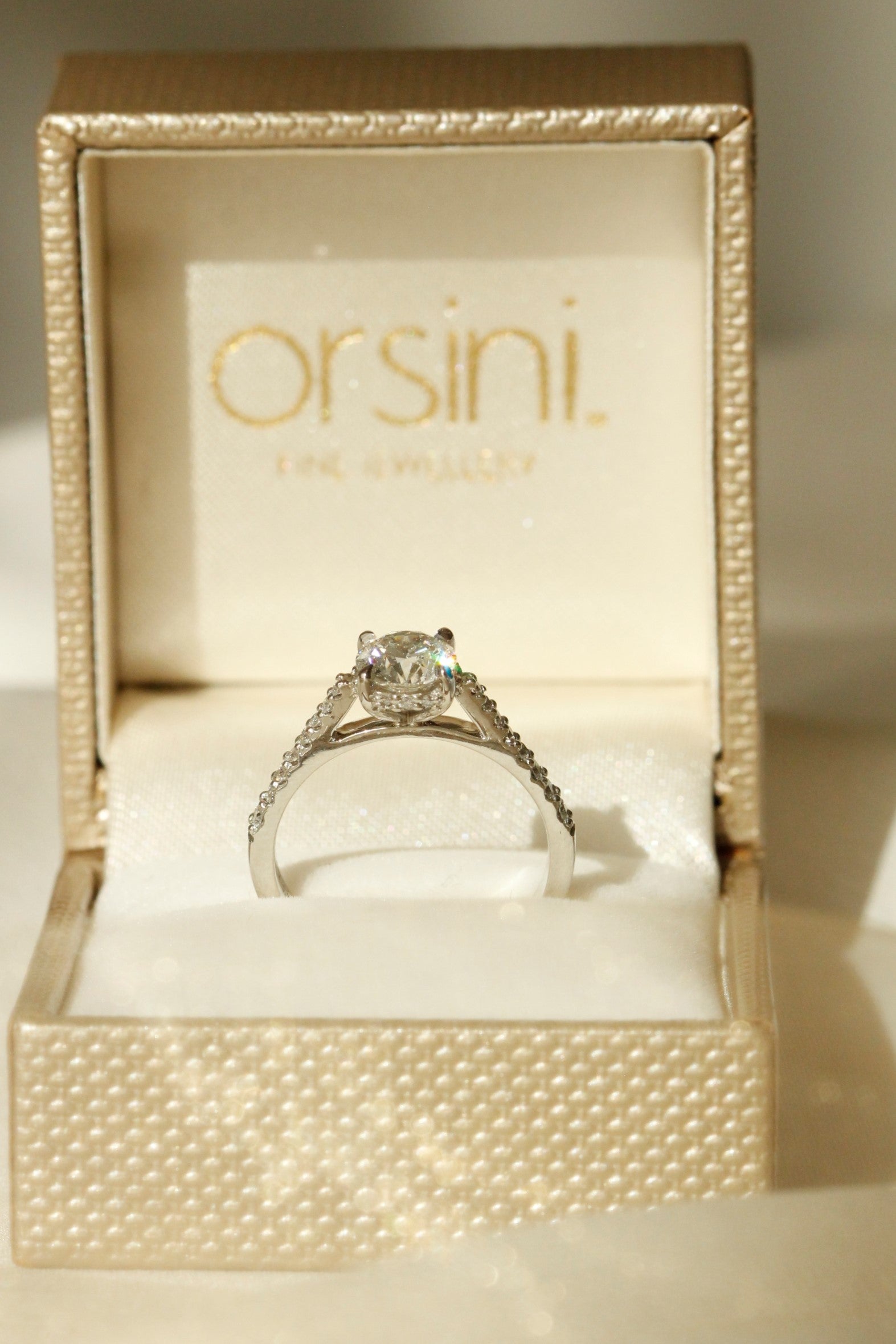 Bernini engagement ring design in gold ring box with gold ribbon