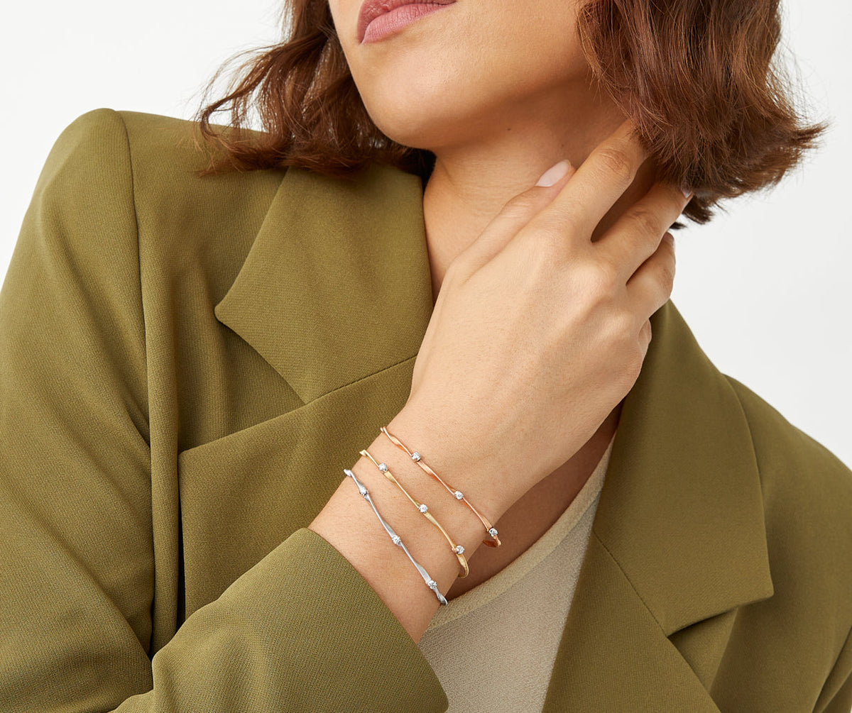 One strand yellow gold with diamonds Marrakech bracelet by Marco Bicego worn with rose and white gold Marrakech bracelets
