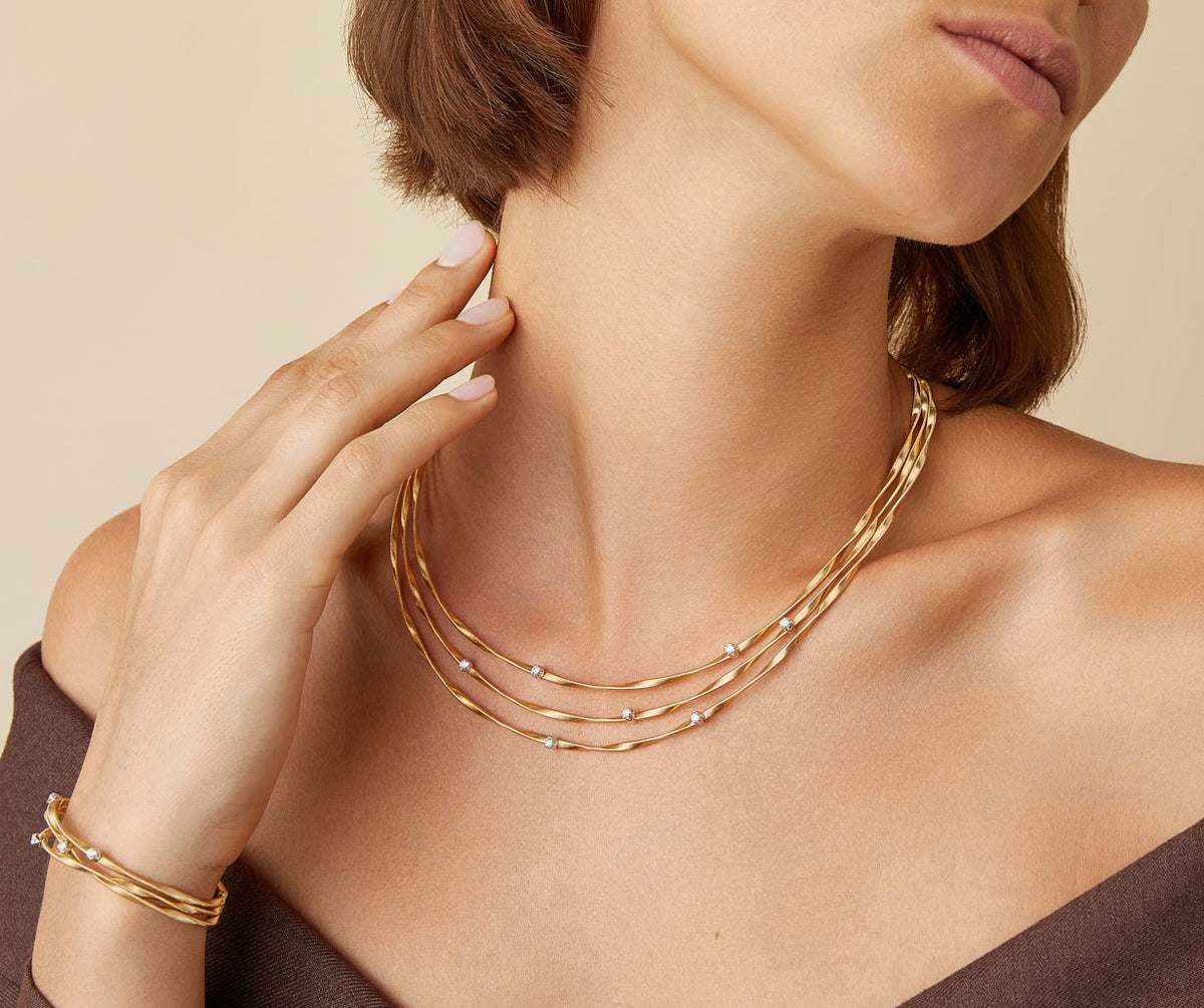 Three strand yellow gold with diamonds Marrakech necklace worn with Marrakech bracelet by Marco Bicego