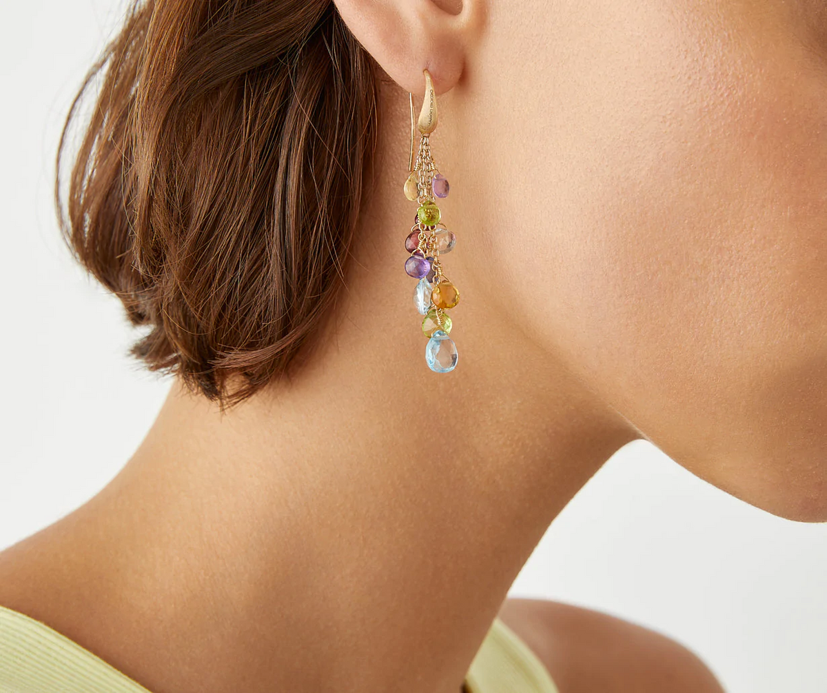 Mixed gemstones and 18k yellow gold three strand drop earrings worn by Marco Bicego