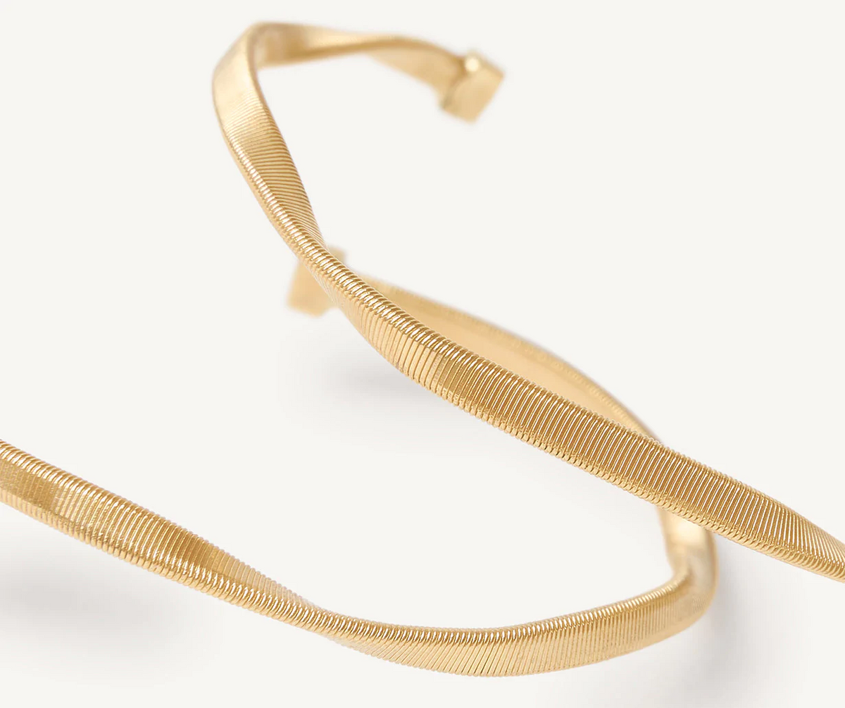 Close up detail of 18k yellow gold hoop earrings by Marco Bicego 